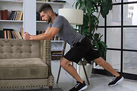 帅哥在家锻炼运动 健康生活的概念 笑声家庭运动员客厅电脑健身房男人身体公寓肌肉训练图片