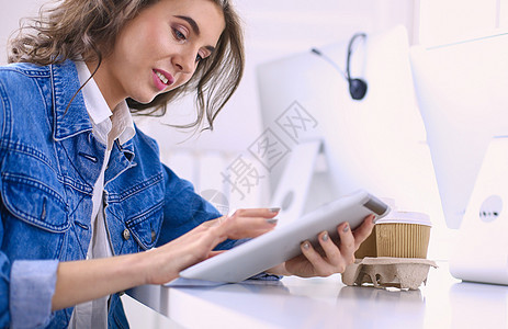 办公室使用数字平板电脑的年轻妇女咖啡上网药片窗户咖啡店幸福女孩笔记本杯子店铺图片