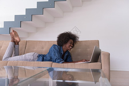 在沙发上使用笔记本电脑的非裔美国妇女女孩女士技术生活快乐房间工作互联网成人女性图片