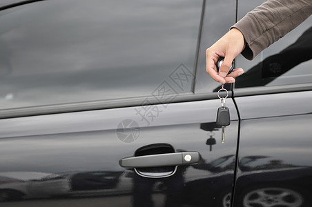 汽车科技线条男性手持汽车钥匙 背景是新黑车背景