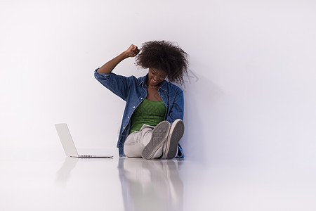 非洲裔美国妇女用笔记本电脑坐在地板上爆炸女士闲暇技术女性成人人行道工作学生互联网图片