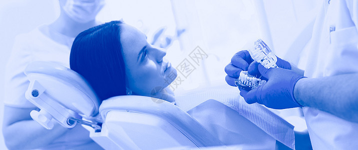 在检查口腔前 年轻有牙医的女士在她身上的照片男人男性卫生手术镜子工具牙疼口服牙科病人图片