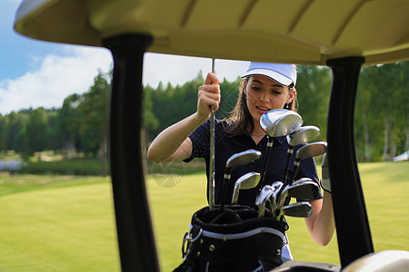 专业女性高尔夫球员 从袋子里选择高尔夫俱乐部男人女士俱乐部竞赛中年运动闲暇玩家男性娱乐图片