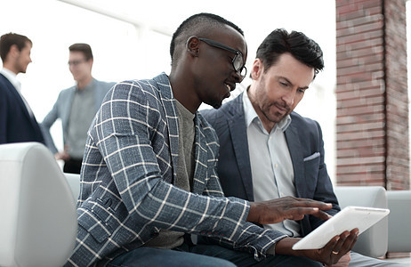 两位商务人士使用数码平板电脑互联网商务讨论企业家套装同事眼镜办公室成人工作图片