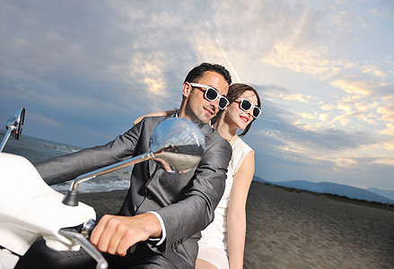 刚结婚的夫妇在海滩上骑白色摩托车成人新娘气球农村婚姻喜悦女性花束女孩蜜月图片