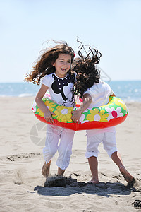快乐的年轻人团体在海滩上玩得开心季节朋友们微笑运动活力乐趣女士闲暇友谊假期图片