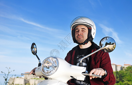 年轻人骑回转式摩托车喜悦危险头盔城市衣服日落运动大路男人男性图片