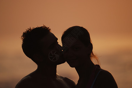海滩上浪漫情侣地平线相机恋人剪影太阳拥抱环境男性季节洞察力图片