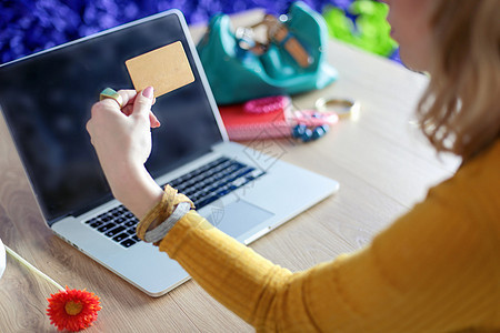 持有信用卡和使用笔记本电脑的青年妇女 网上购物概念商务金融工作办公室女孩购物风险店铺安全工人图片