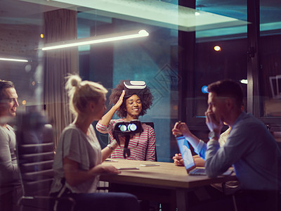 使用虚拟现实头盔的多族裔多族裔商业团队同事开发商桌子设计师技术玩家虚拟现实办公室乐趣会议图片