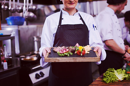 女性厨师持有牛肉牛排板餐厅食谱桌子美食牛扒烹饪厨房食物蔬菜职业图片