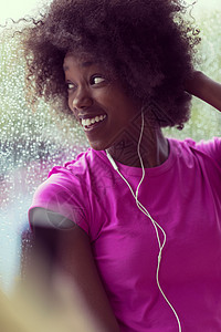 年轻美籍女子在体育场听音乐时的肖像运动员运动装训练饮食女士窗户天气电话舞蹈身体图片