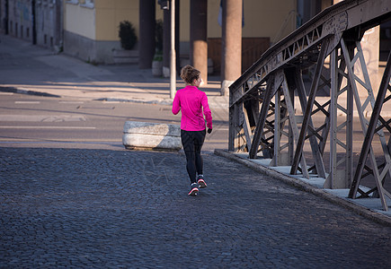 运动女运动员早上慢跑女士赛跑者跑步闲暇日落训练公园人行道城市日出图片