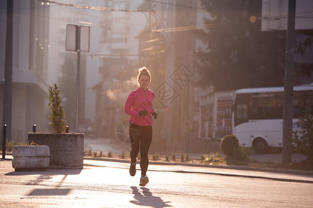运动女运动员早上慢跑城市卷曲日落女性慢跑者成人公园日出闲暇活力图片