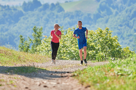 夫妻在乡村路上慢跑时享受健康的生活方式 在农村公路上游骑运动装训练女士公园运动员女性男性行动朋友们赛跑者图片