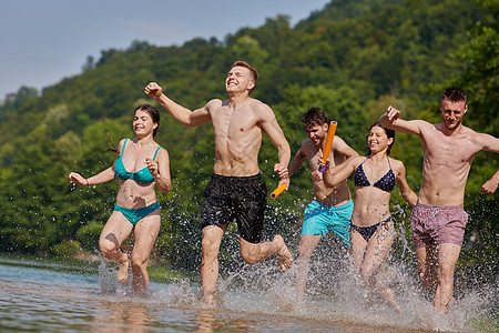 一群快乐的朋友在河边玩乐青少年闲暇派对男人日落跳跃友谊家庭青年晴天图片