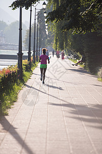 非洲裔美国女性在城里慢跑运动女孩人行道运动员跑步训练城市公园日出慢跑者图片