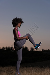 黑人妇女正在做伸展锻炼 放松和温暖生活运动成人活力日落幸福草地身体女士训练图片