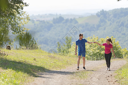 夫妻在乡村路上慢跑时享受健康的生活方式 在农村公路上游骑练习公园赛跑者朋友们太阳跑步日光女孩男人运动员图片