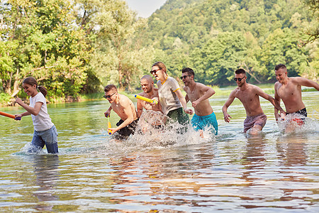 一群快乐的朋友在河边玩乐游泳衣学生女士假期青年冒险家庭男生跳跃海滩图片