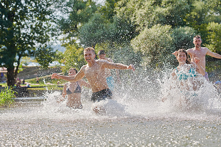一群快乐的朋友在河边玩乐跑步游泳家庭青少年男生男人晴天派对学生女士图片