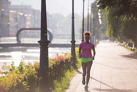 非洲裔美国女性在城里慢跑人行道运动运动员日落日出公园女孩闲暇跑步训练图片