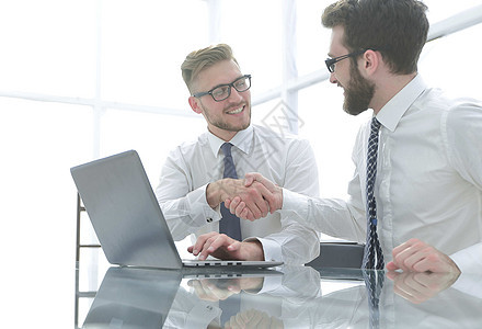 商业同事彼此握手 相互握手会议桌面头脑桌子蓝图电脑商务合作男人公司图片