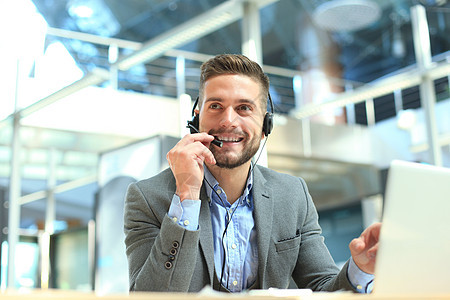 微笑友好英俊的年轻男性呼叫中心接线员商业快乐人士操作员技术商务麦克风员工男人电话图片