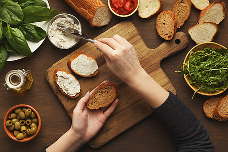 女性手制作蔬菜布鲁谢塔的顶端视图面包木板小吃乡村早餐野餐食物黄瓜美食配料图片