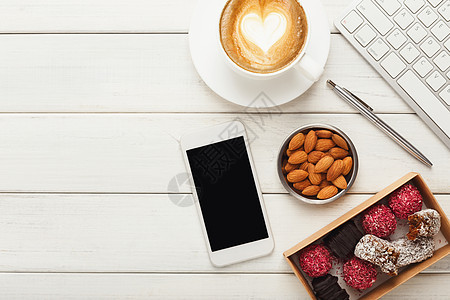 与健康的糖果和坚果一起工作咖啡杯子松露椰子腰果盒子养分键盘手机展示图片
