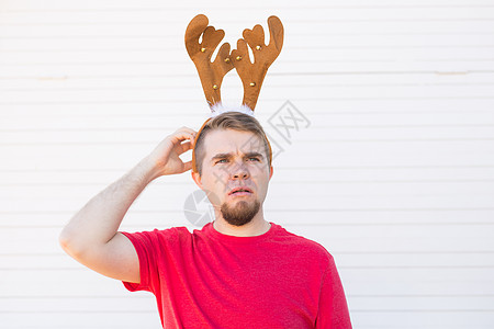 圣诞节 假期和人们的概念  一个长着鹿角的男人的头 男人挠头惊喜季节化妆品魔法喇叭金属男性微笑工作室嘴唇图片