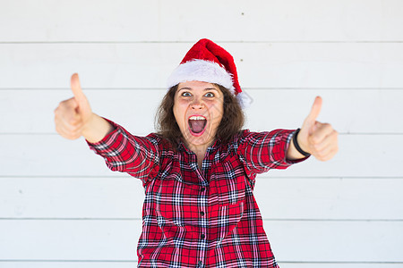 圣诞节和人的概念 — 戴着圣诞帽的女人竖起大拇指图片