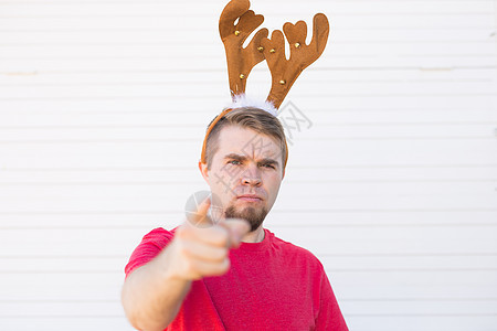 圣诞 人们 情绪概念  不满的愤怒的人 在基督之鹿角 指着观看者喇叭男性男人假期乐趣成人帽子孤独男生胡子图片