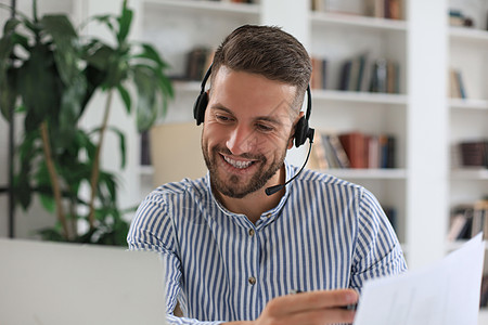 在线分析在办公室有视频通话的年轻商务人士微笑着工作男性眼镜电脑技术地点笔记本加班经理推销背景