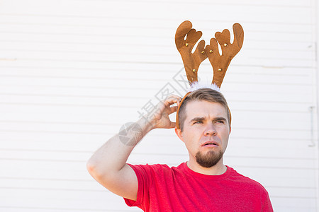 圣诞节 假期和人们的概念  一个长着鹿角的男人的头 男人挠头新年传统魔法惊喜男性微笑喇叭金属嘴唇驯鹿图片