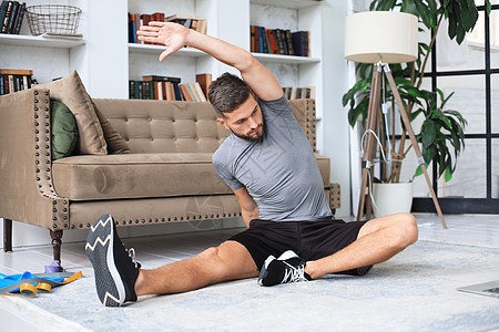 英俊的男人在家里做伸展运动 健康生活的概念 笑声俯卧撑健身房家庭房子肌肉活动闲暇训练爱好运动员图片