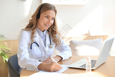 集中精神的医生在网上工作 笔记本电脑坐在一个桌子上进行咨询成人医院药品女士学生保健写作网络服务互联网图片