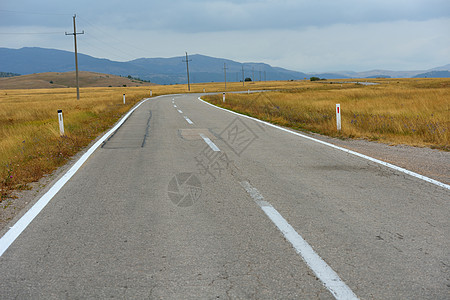 穿越绿地的道路驾驶草地天空速度运输蓝色自由晴天森林地平线图片