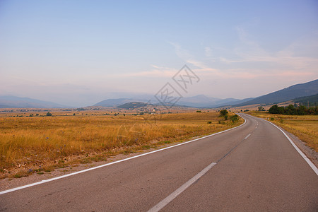 穿越绿地的道路驾驶沥青天空日出晴天农村爬坡运输交通运动图片