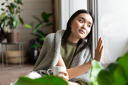 在家自我隔离的年轻女子 坐在窗户旁边 触摸玻璃 看外面 喝着咖啡以及鼻子肺炎心碎杯子卫生感染房子保健温度疼痛图片