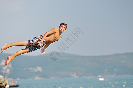 男孩跳海游泳海滨地平线旅行技巧活力喜悦身体蓝色闲暇图片