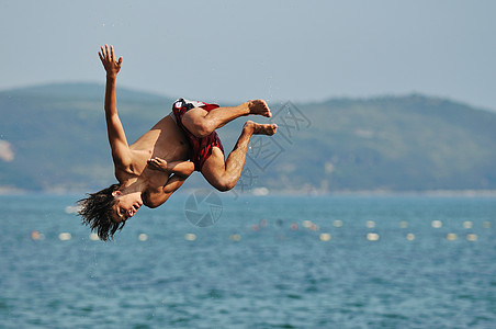 男孩跳海地平线蓝色游泳空气青年潜水活力自由乐趣海洋图片
