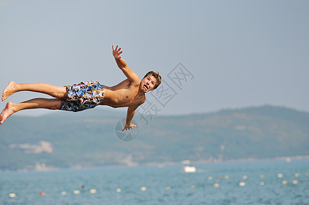 男孩跳海乐趣男人热带海滨青年旅行天空运动孩子技巧图片