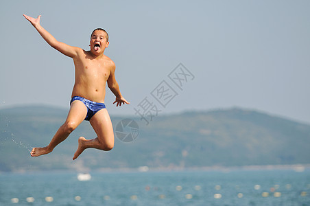 男孩跳海蓝色旅行海洋海岸波浪运动天空活力闲暇地平线图片