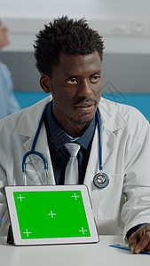 做医生的人指着绿色屏风屏幕技术设施小样药品医院保健长老处方疾病图片