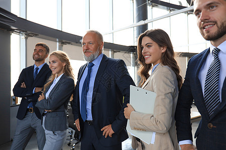 快乐的笑脸商业团队站在办公室排队成人经理工作人士套装女孩团体合伙男人微笑图片