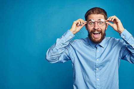 戴眼镜的男商务人士情绪色彩蓝背景胡须工作衬衫工作室办公室喜悦经理领带成人男生图片