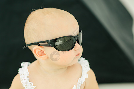 童年概念 对带太阳眼镜的小婴儿的画像生活喜悦太阳镜孩子乐趣微笑工作室快乐女孩女儿图片