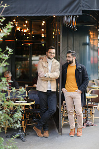 男性帅哥朋友站着在街上咖啡厅聊天图片