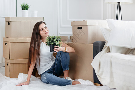 年轻女人梦想坐在新公寓的地板上 在新的公寓里贷款包装男人开箱房子纸盒屋主女孩家庭服务图片